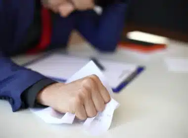 Homme froissant un papier administratif