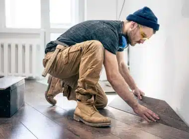 Artisan posant du parquet sur du carrelage